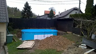 Částečně zapuštěný oválný bazén usazený na betonovou desku
