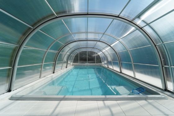 Vysoké obloukové zastřešení prodloužené za bazén s převlíkací a relaxační částí